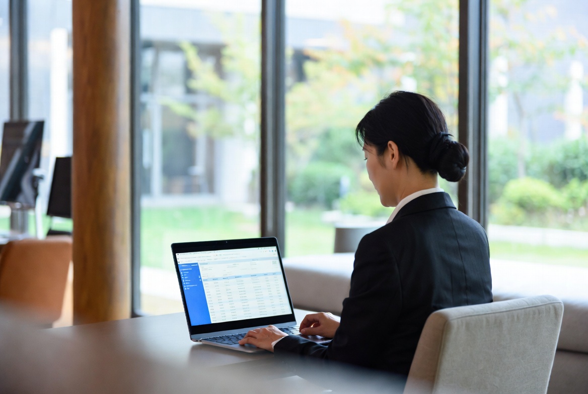 조용한 오피스 라운지에서 노트북을 이용해 법인 차량의 보험 내역과 세무 신고서를 사전 점검하는 모습