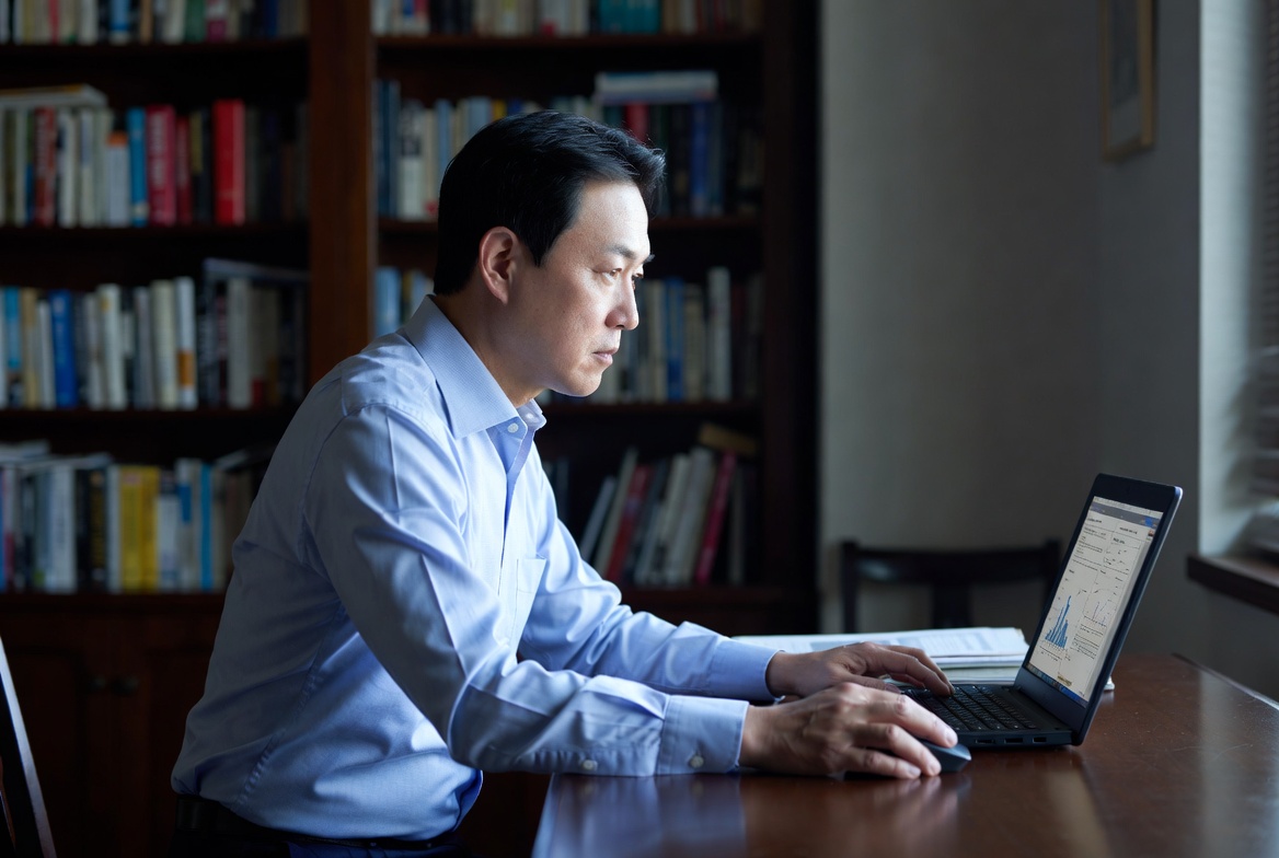 45~55세 한국 남성이 자택 서재에서 진지한 표정으로 노트북 화면을 보며 즉시연금 비과세 한도를 검토하는 모습